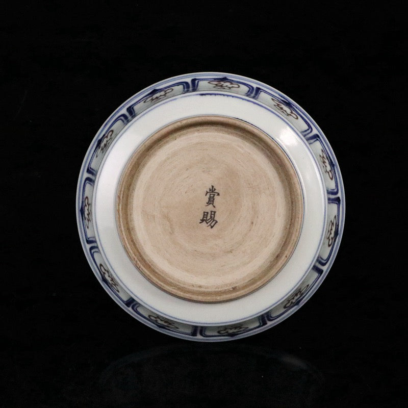 Blue and white glazed dish with red fish and algae patterns