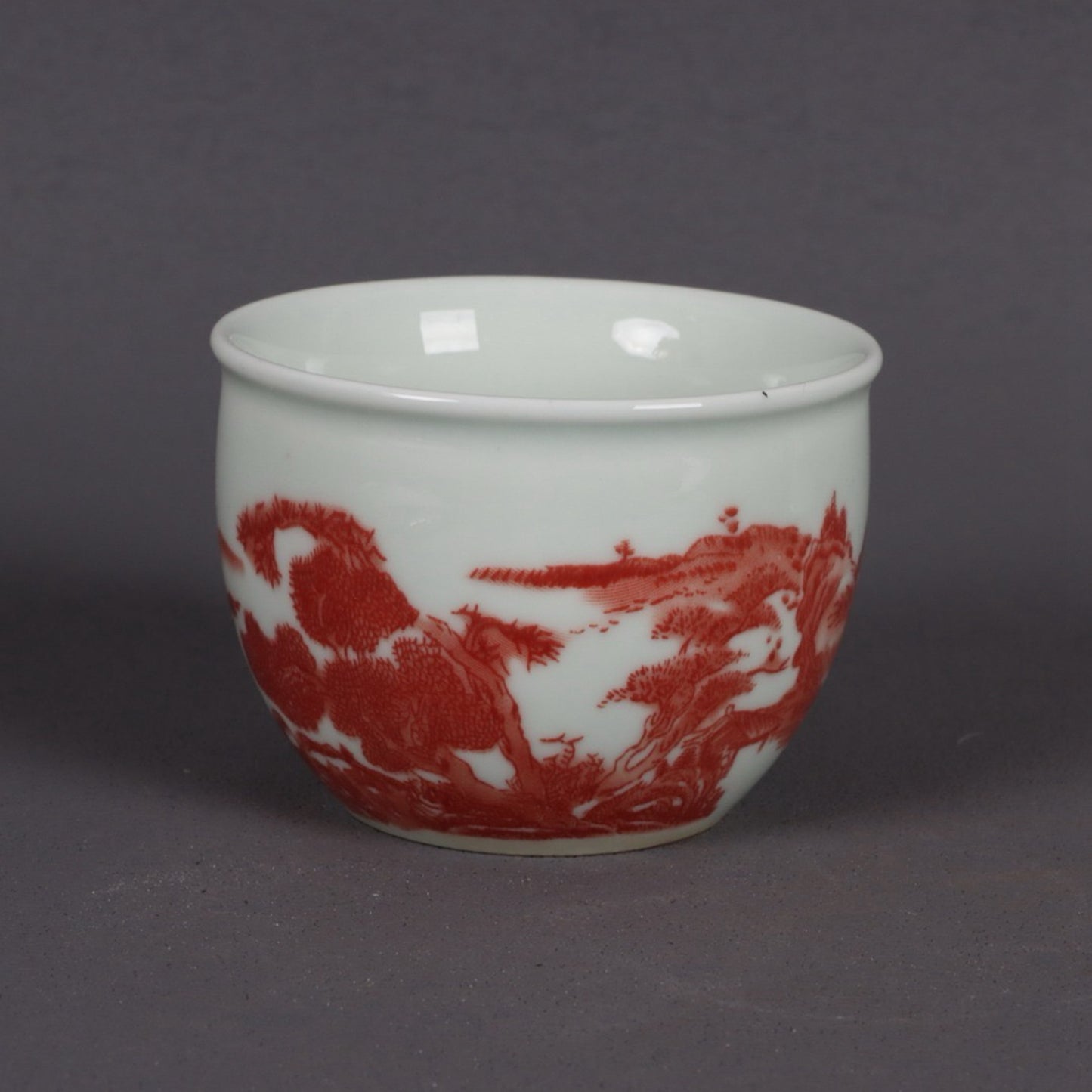 A pair of glazed red landscape patterned mouth cups