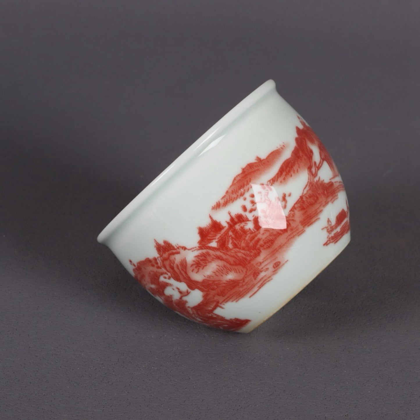 A pair of glazed red landscape patterned mouth cups