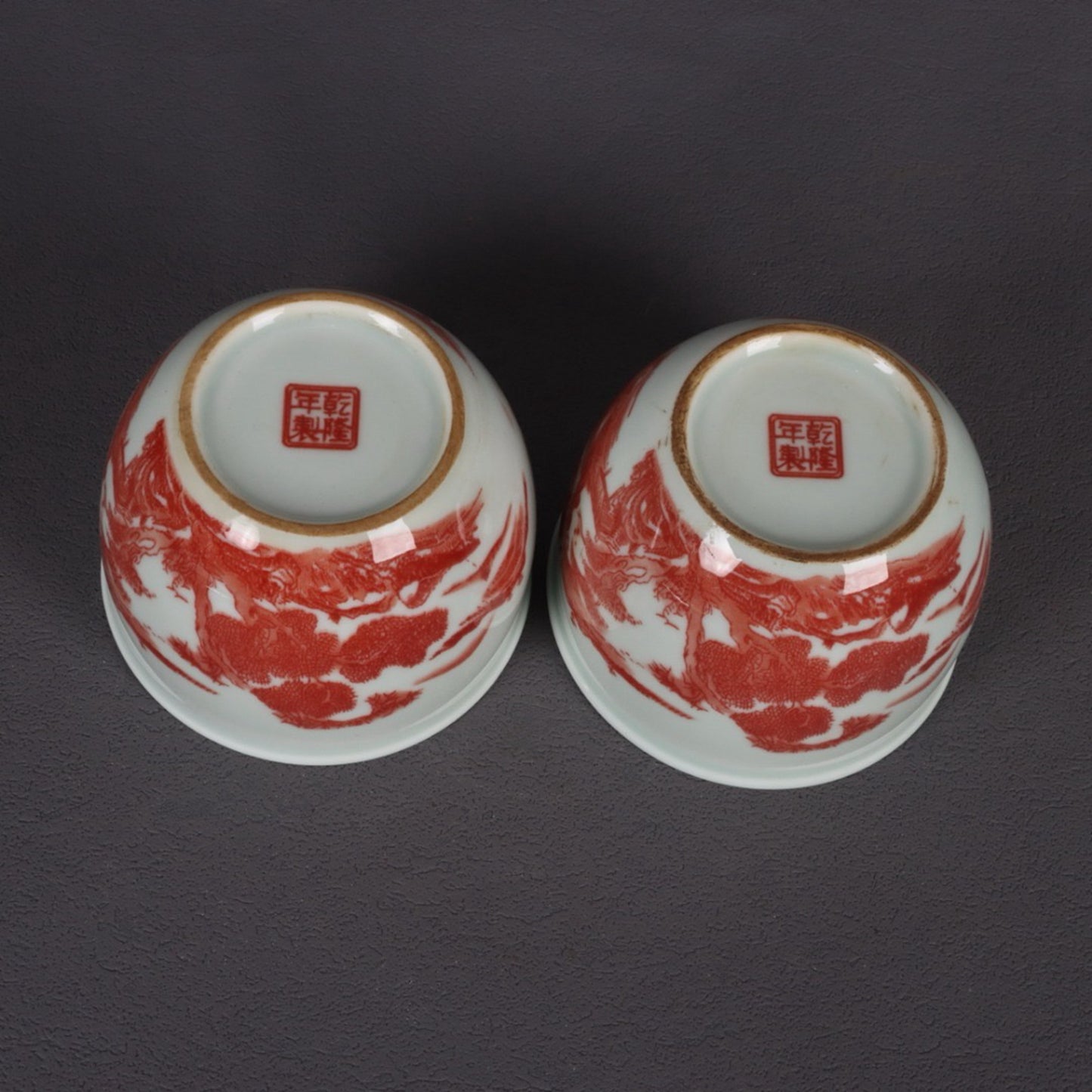 A pair of glazed red landscape patterned mouth cups