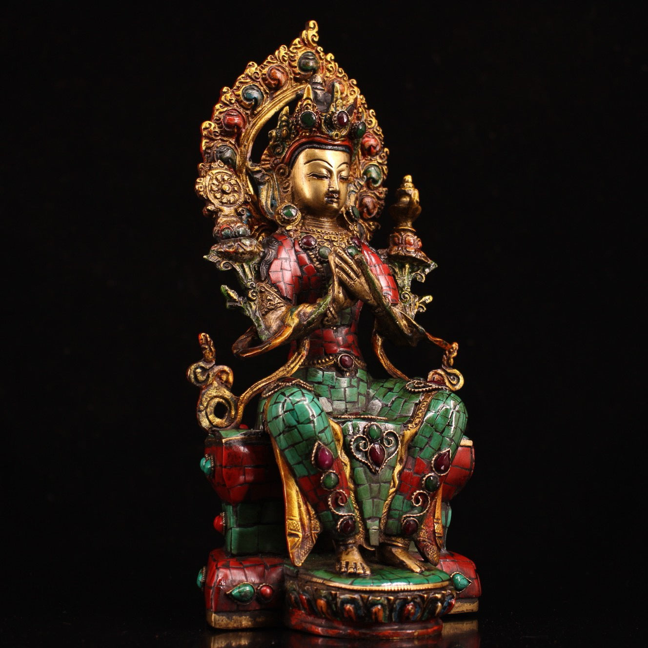 A pure copper handmade statue with inlaid gemstones, colorful paintings, and golden depictions, featuring a Buddha statue