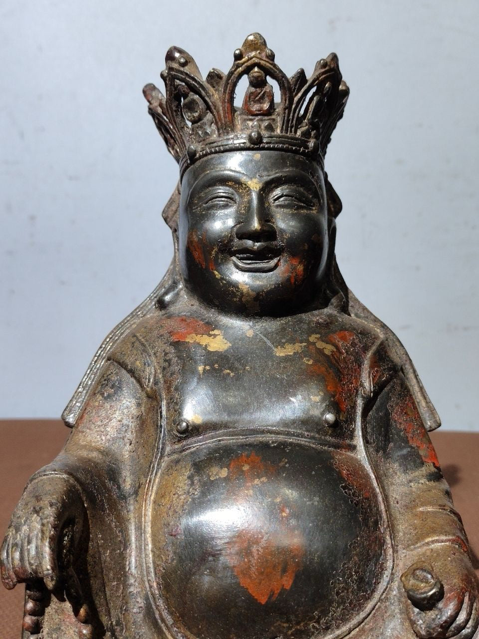 A statue of Maitreya Buddha with a large belly, made of copper, mud, gold, blooming, and sprinkled with cinnabar