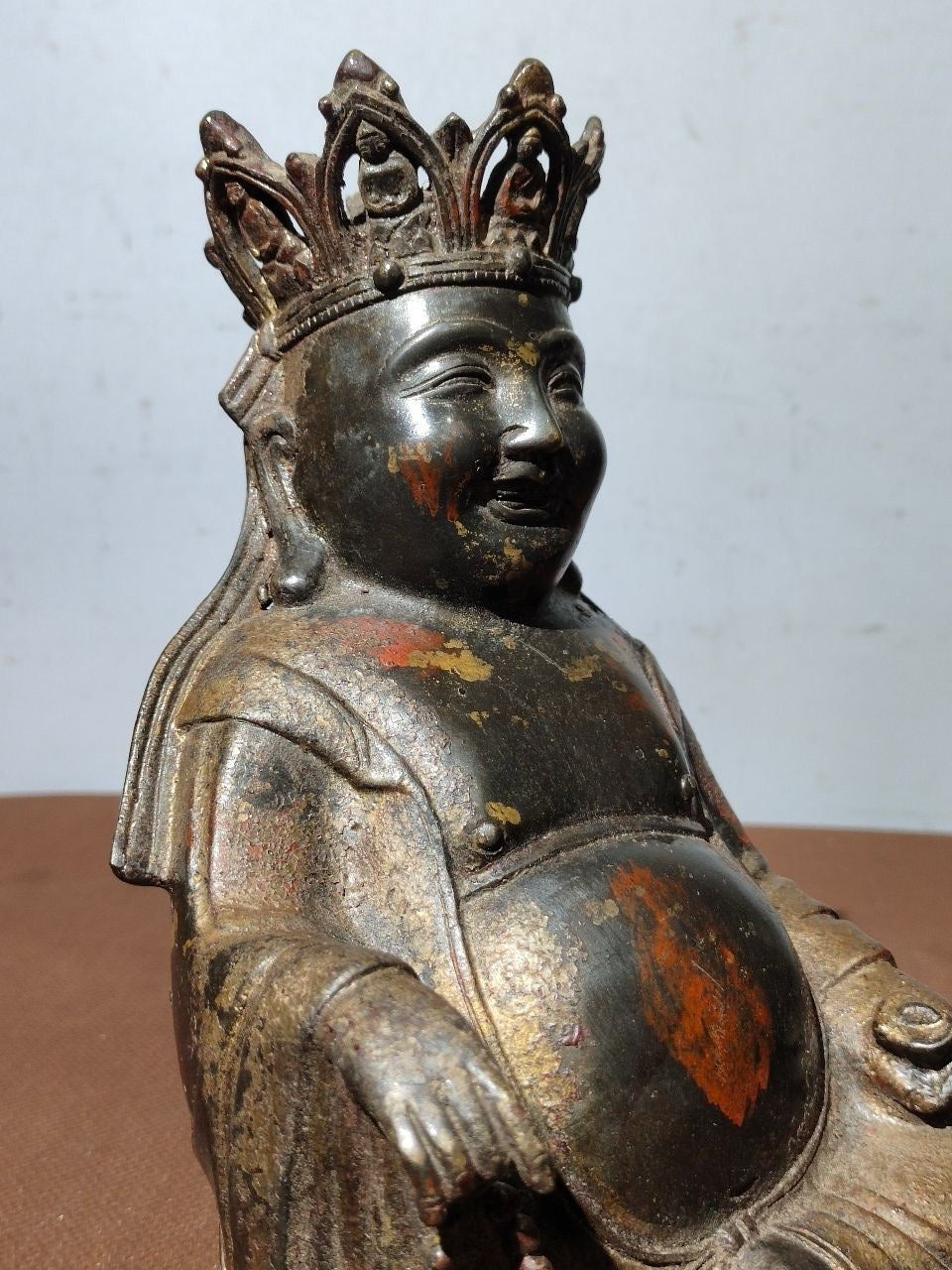 A statue of Maitreya Buddha with a large belly, made of copper, mud, gold, blooming, and sprinkled with cinnabar