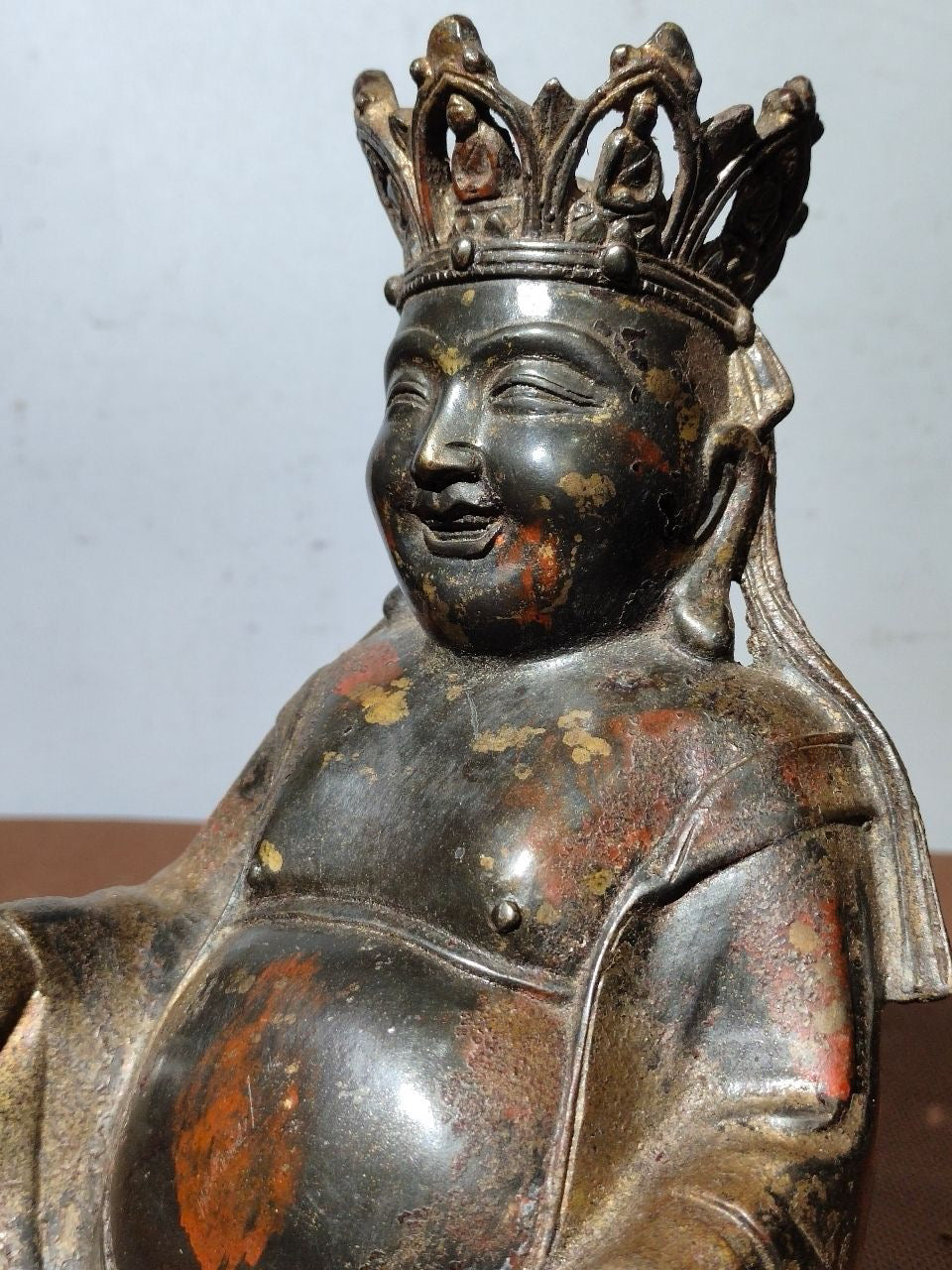 A statue of Maitreya Buddha with a large belly, made of copper, mud, gold, blooming, and sprinkled with cinnabar
