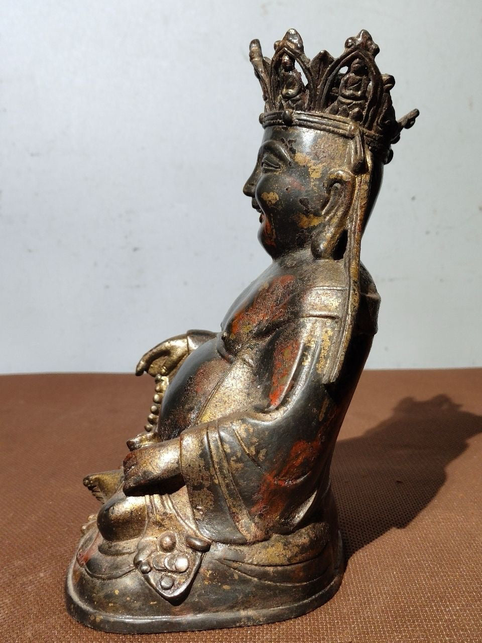 A statue of Maitreya Buddha with a large belly, made of copper, mud, gold, blooming, and sprinkled with cinnabar