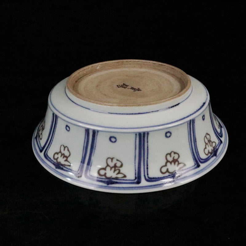 Blue and white glazed dish with red fish and algae patterns