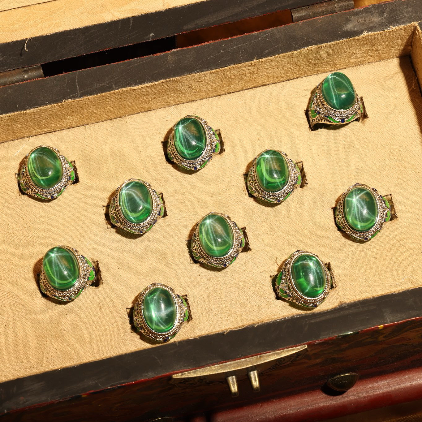 A box of green starry gemstone cloisonne rings