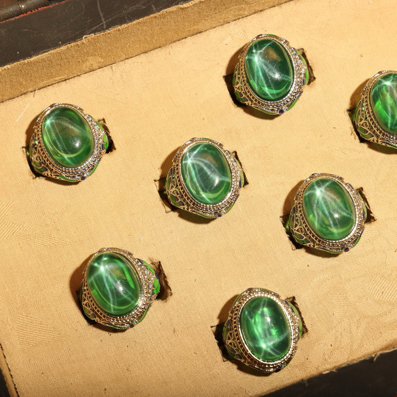 A box of green starry gemstone cloisonne rings