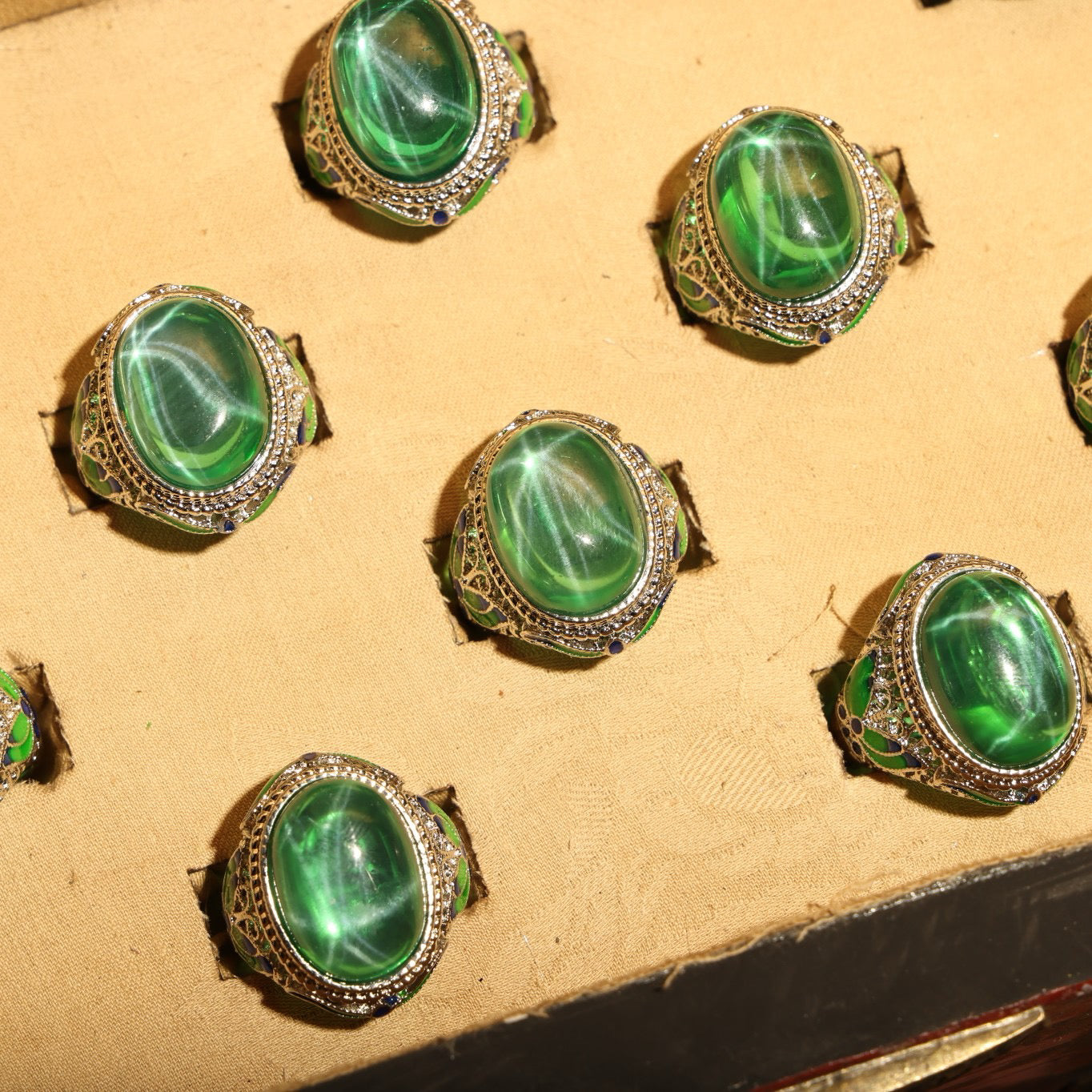 A box of green starry gemstone cloisonne rings