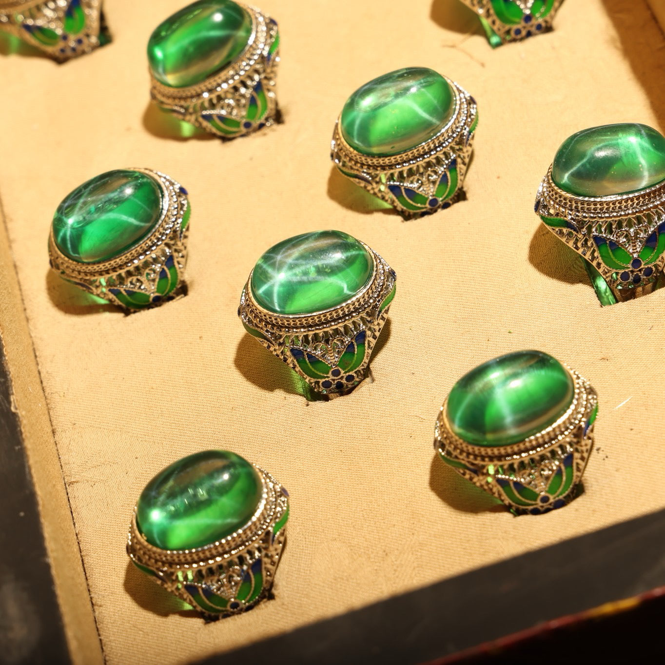 A box of green starry gemstone cloisonne rings