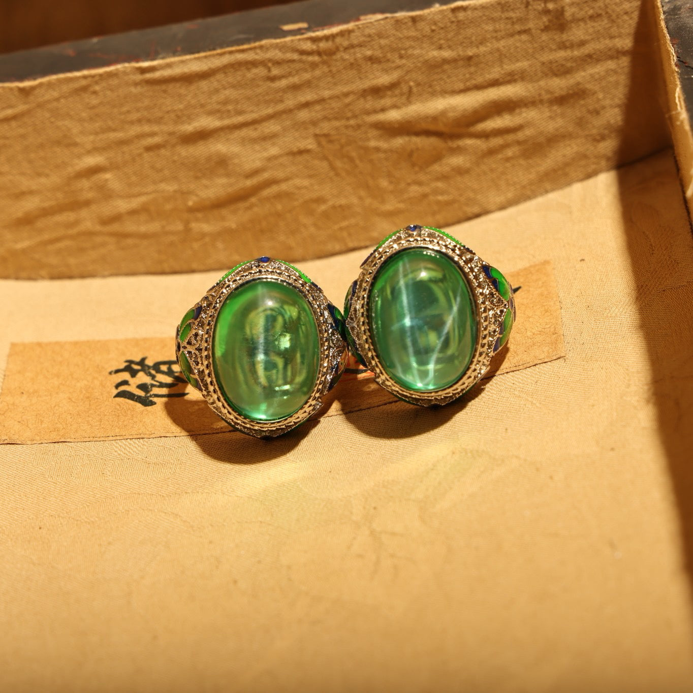 A box of green starry gemstone cloisonne rings