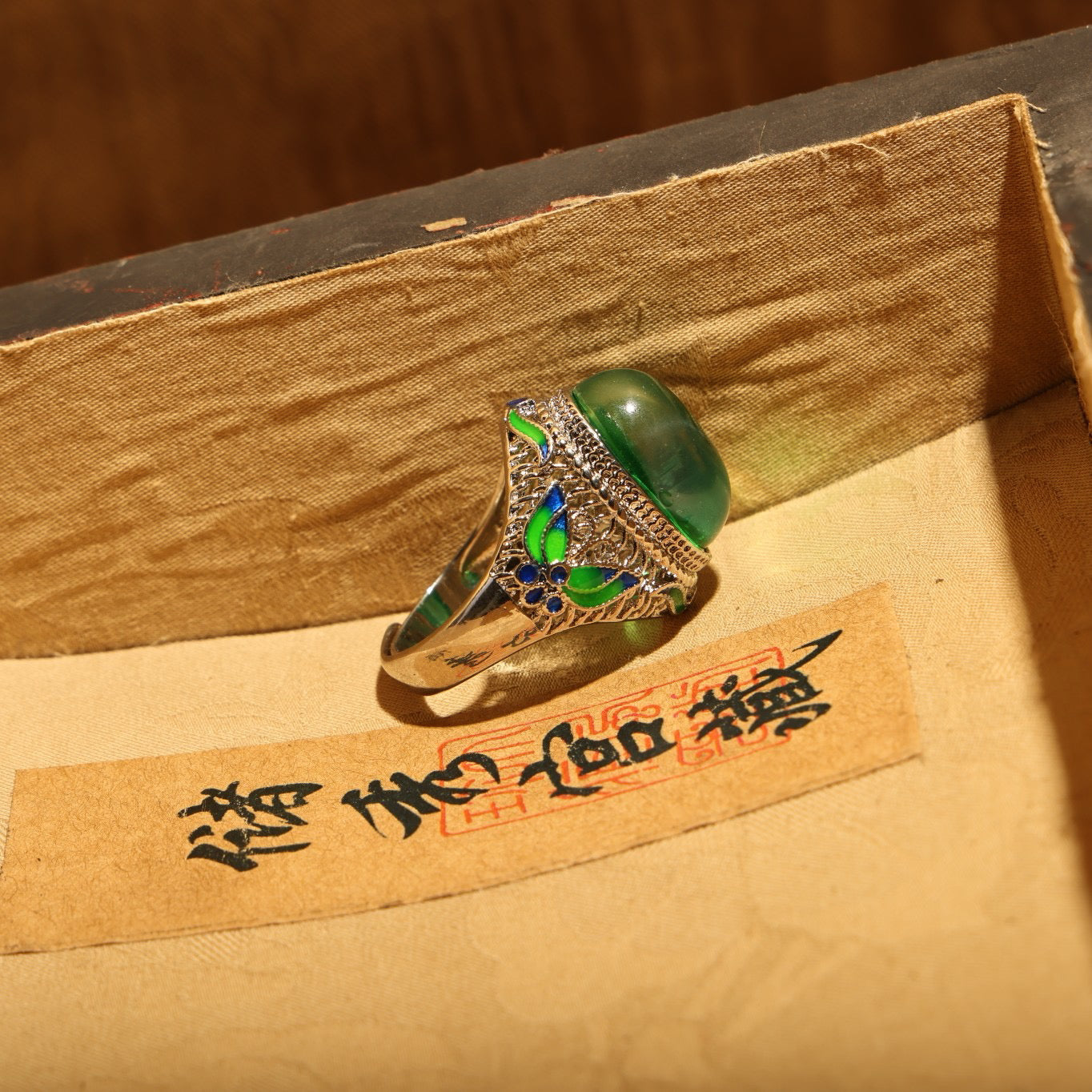 A box of green starry gemstone cloisonne rings