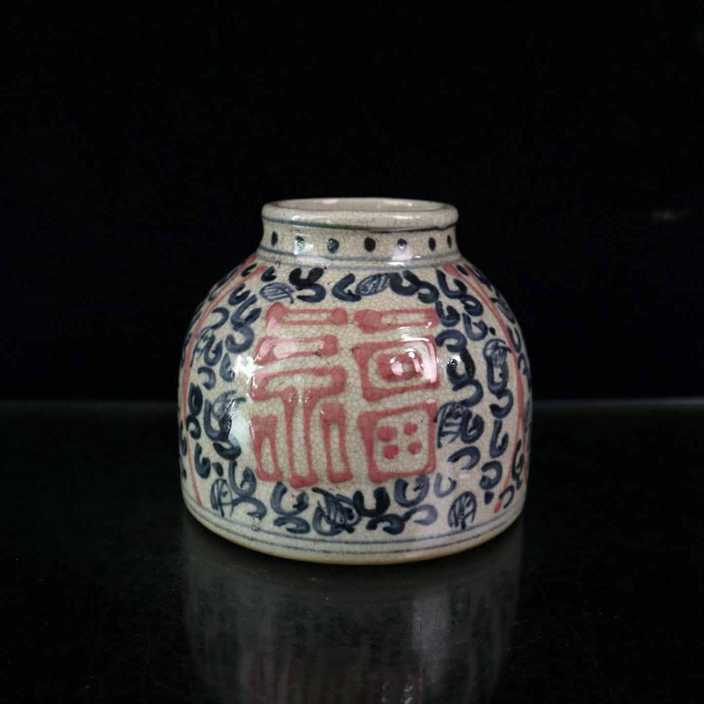 Open piece blue and white glazed jar with red and lucky character pattern