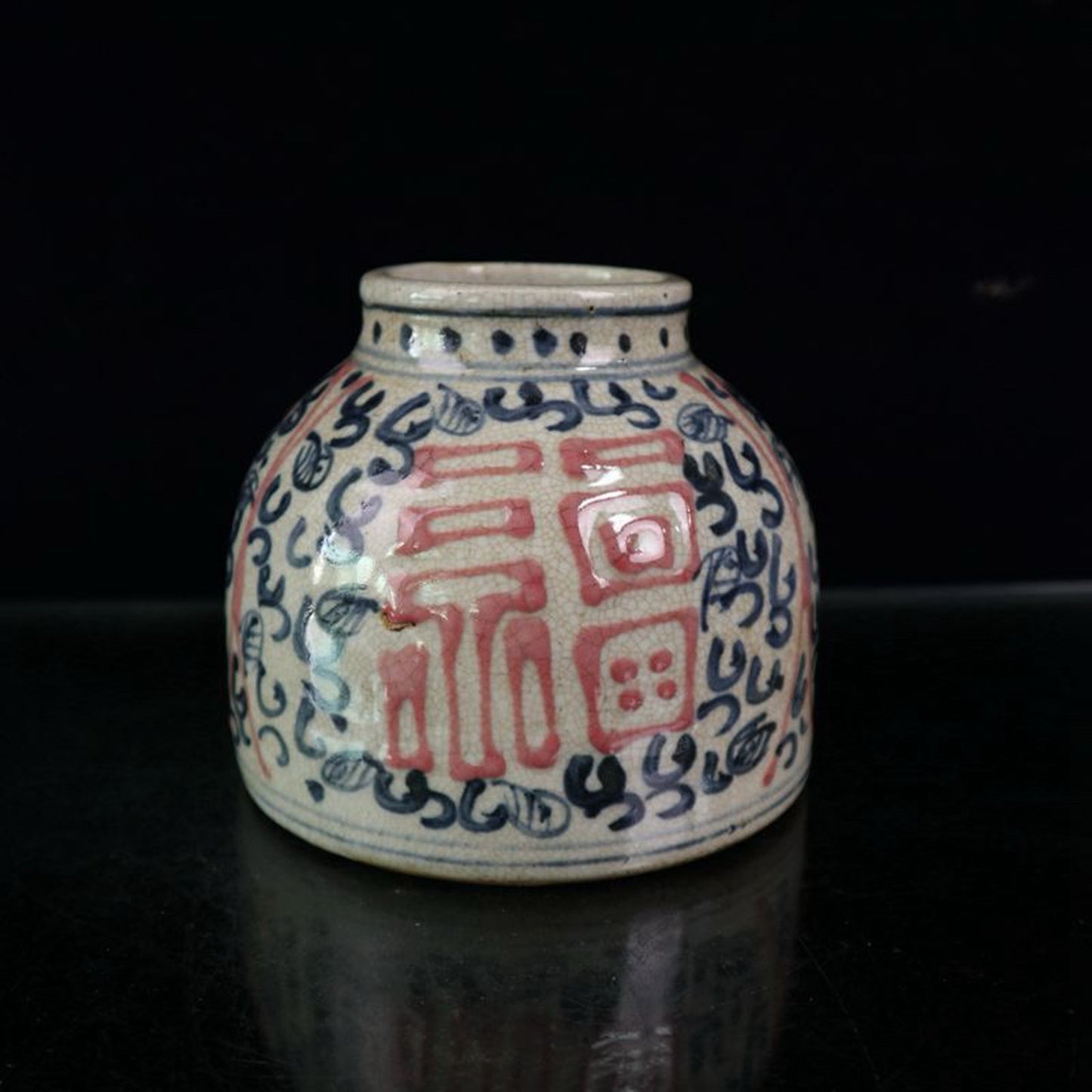 Open piece blue and white glazed jar with red and lucky character pattern