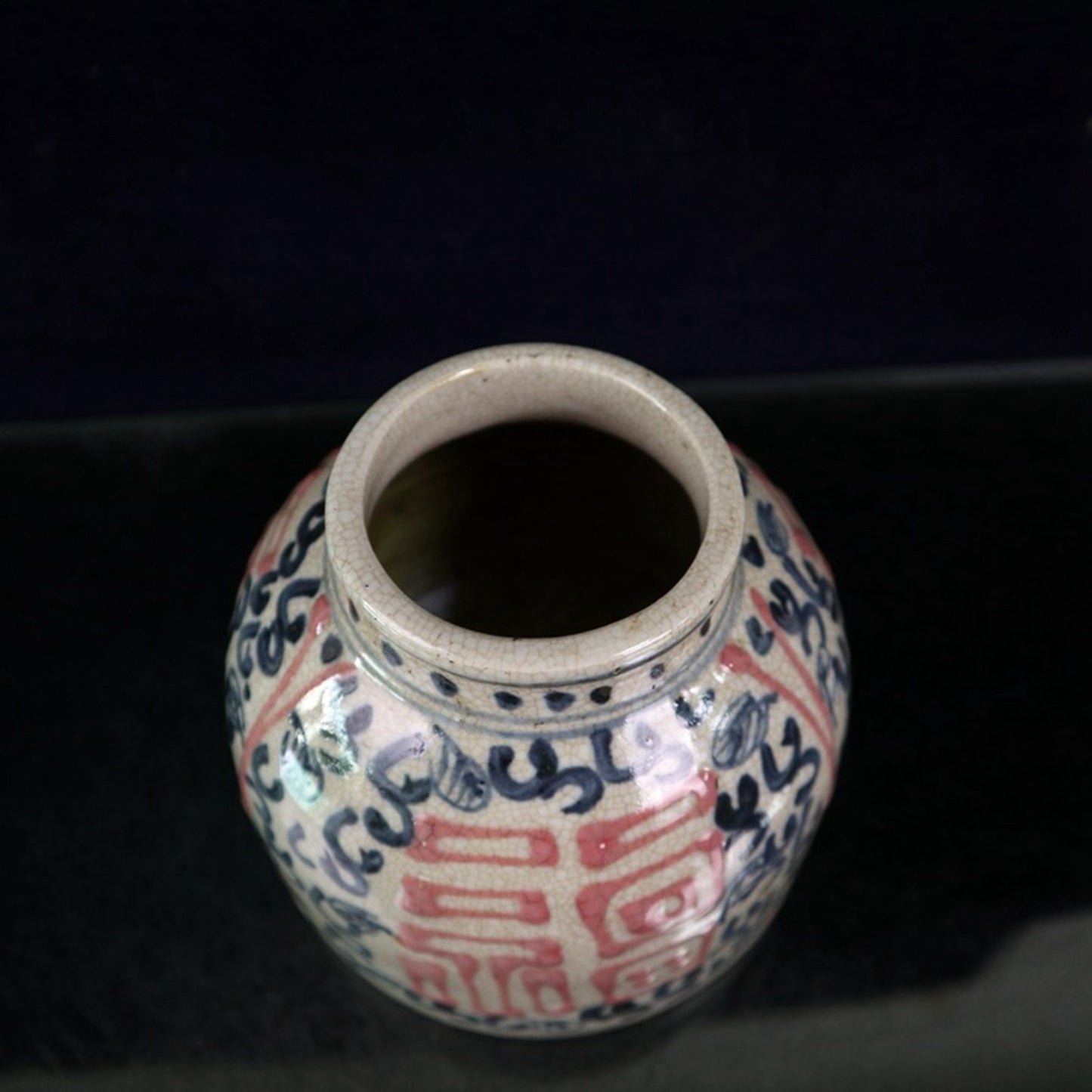 Open piece blue and white glazed jar with red and lucky character pattern
