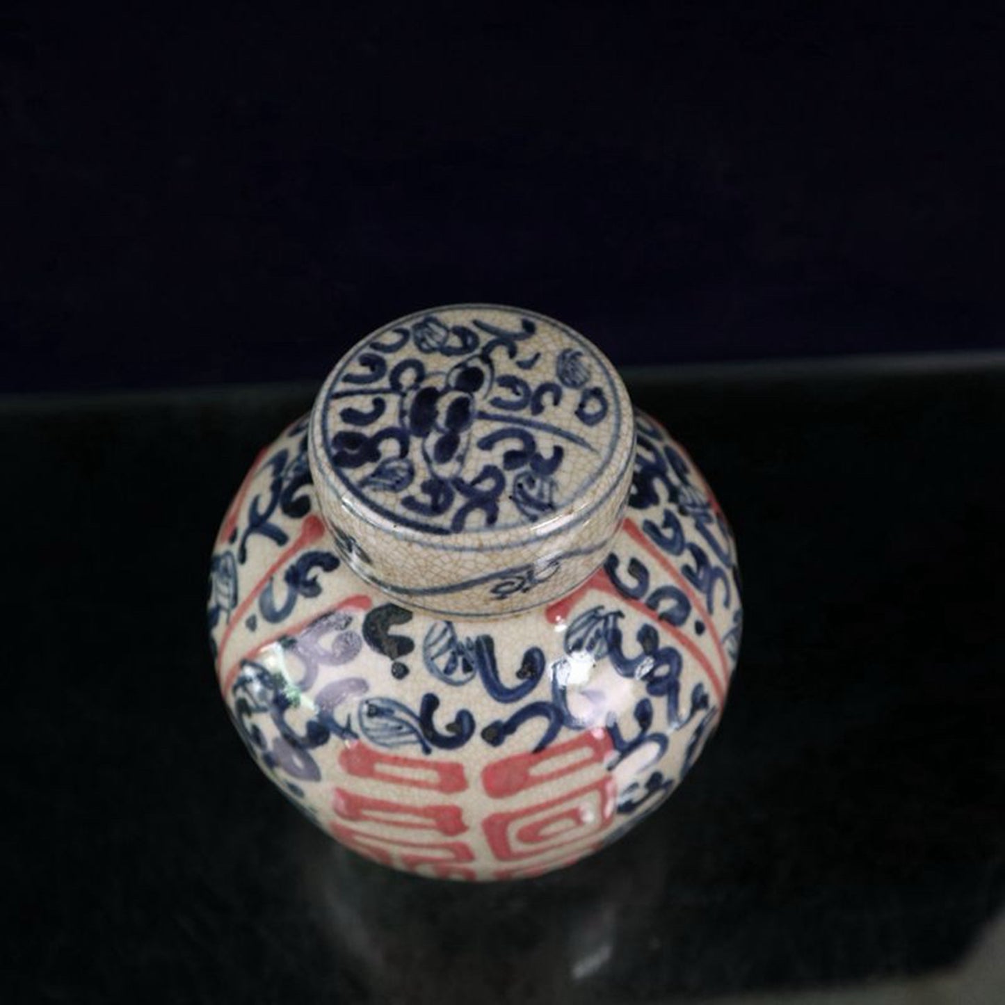 Open-piece blue and white glazed jar with a red blessing pattern lid