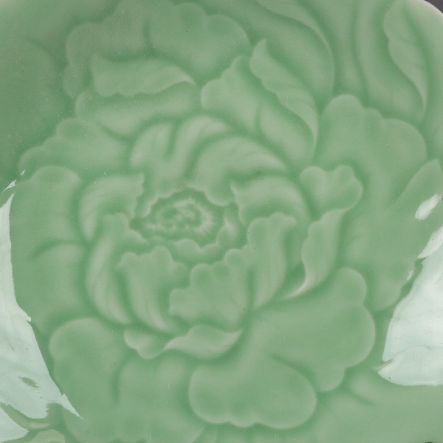 Appreciation plate with peony patterns carved on bean green glaze