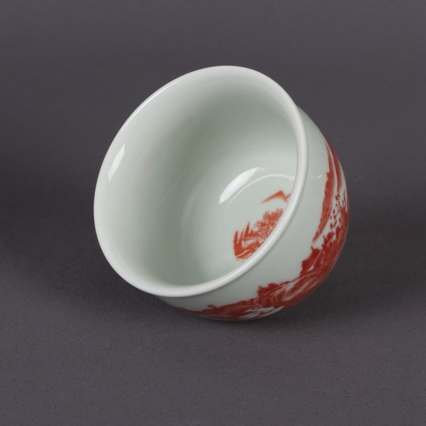 A pair of glazed red landscape patterned mouth cups