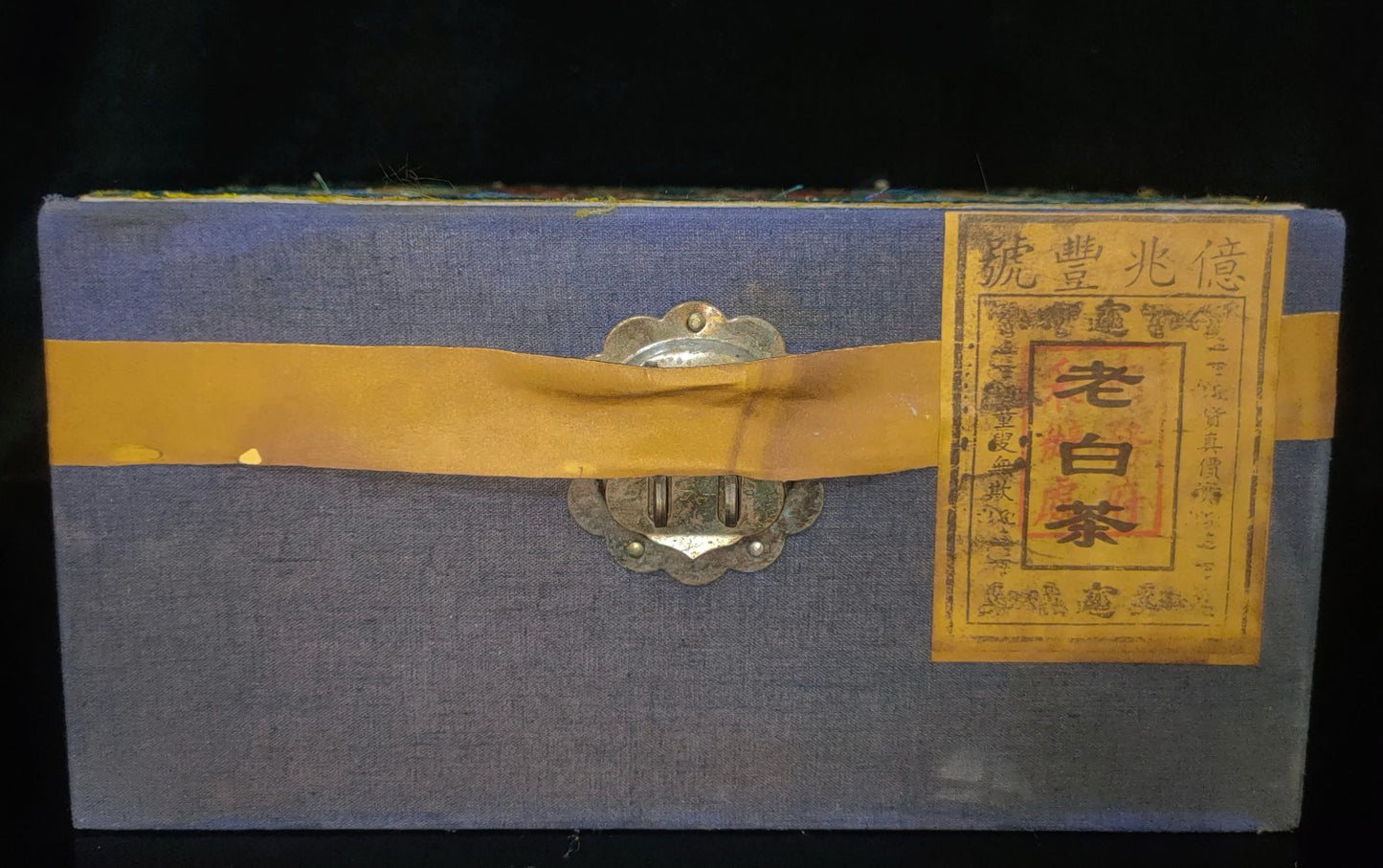 Old white tea inside the brocade box