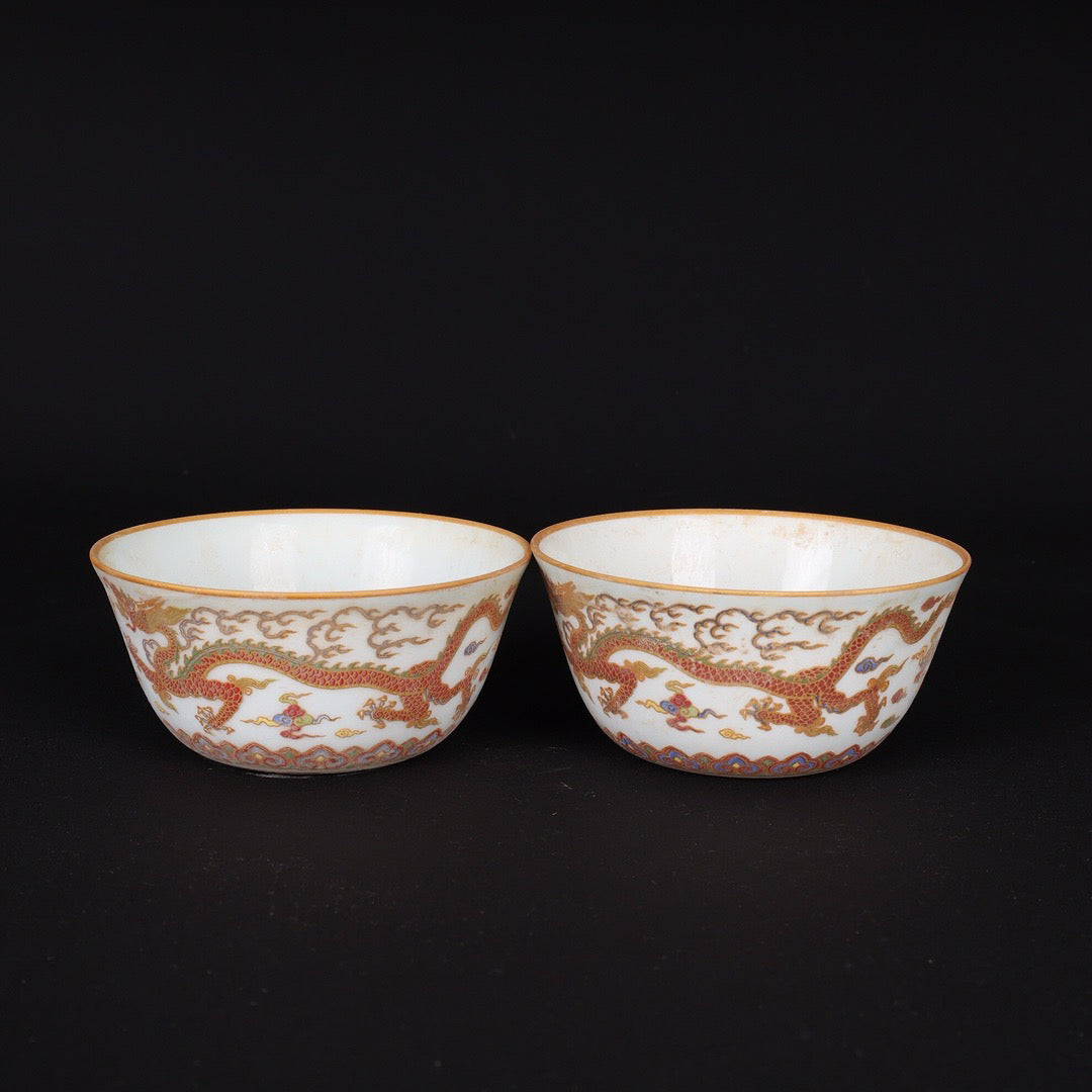 A pair of Chinese antique flat bottomed cups with patterns of double dragons playing with pearls