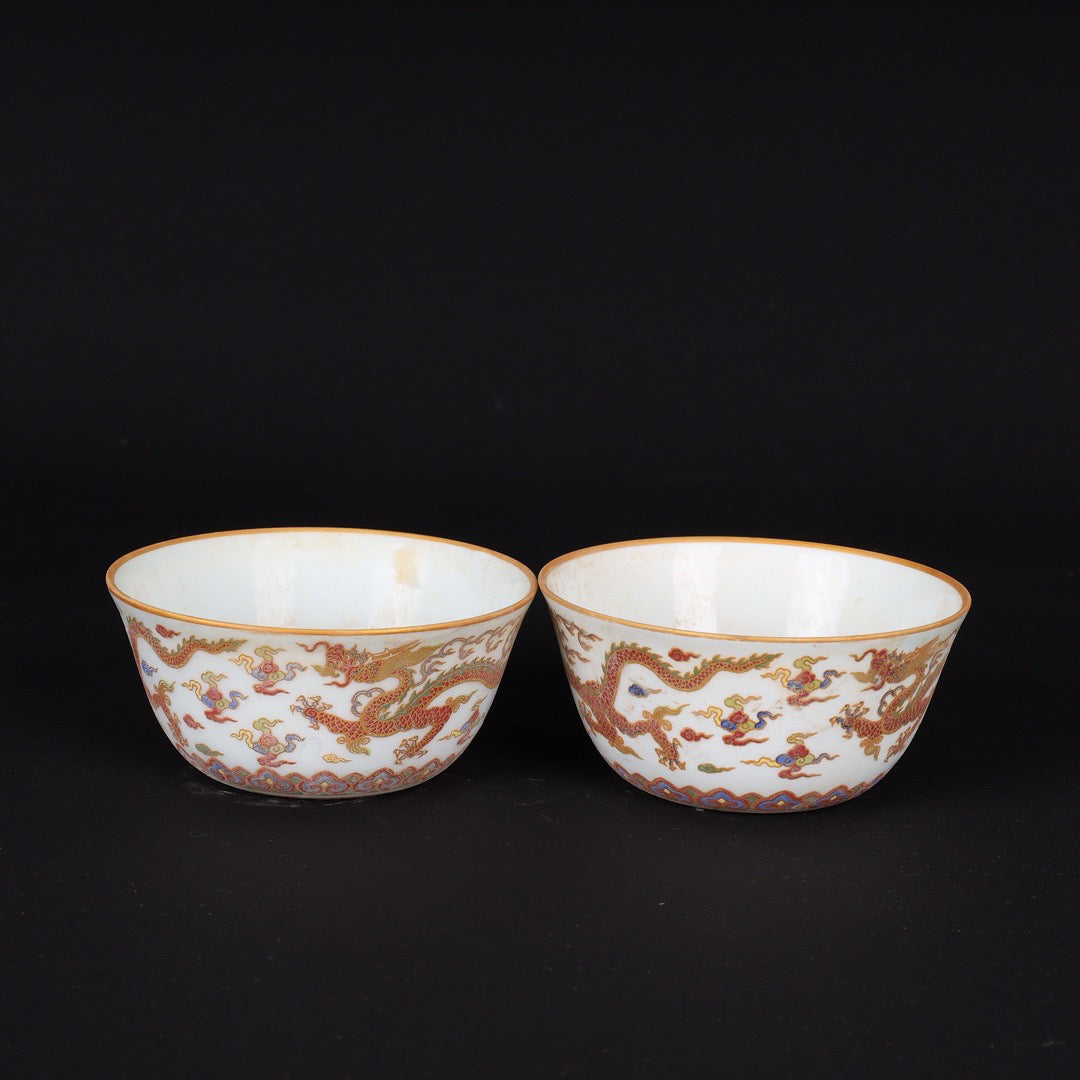 A pair of Chinese antique flat bottomed cups with patterns of double dragons playing with pearls