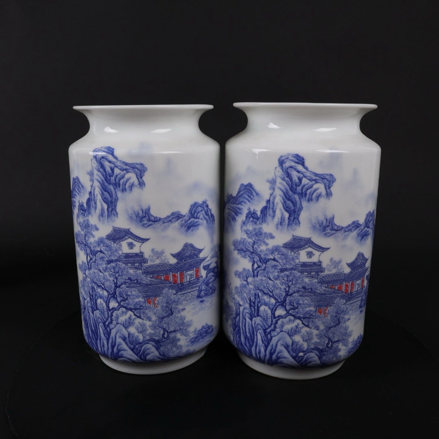 A pair of blue and white vases with mountain and water patterns