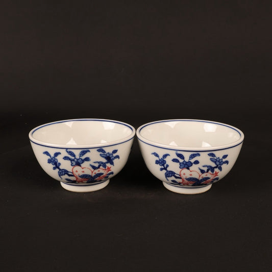 A pair of hand pressure cups with blue and white enamel, red blessings and longevity pictures