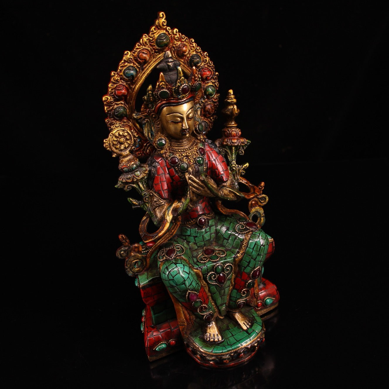 A pure copper handmade statue with inlaid gemstones, colorful paintings, and golden depictions, featuring a Buddha statue