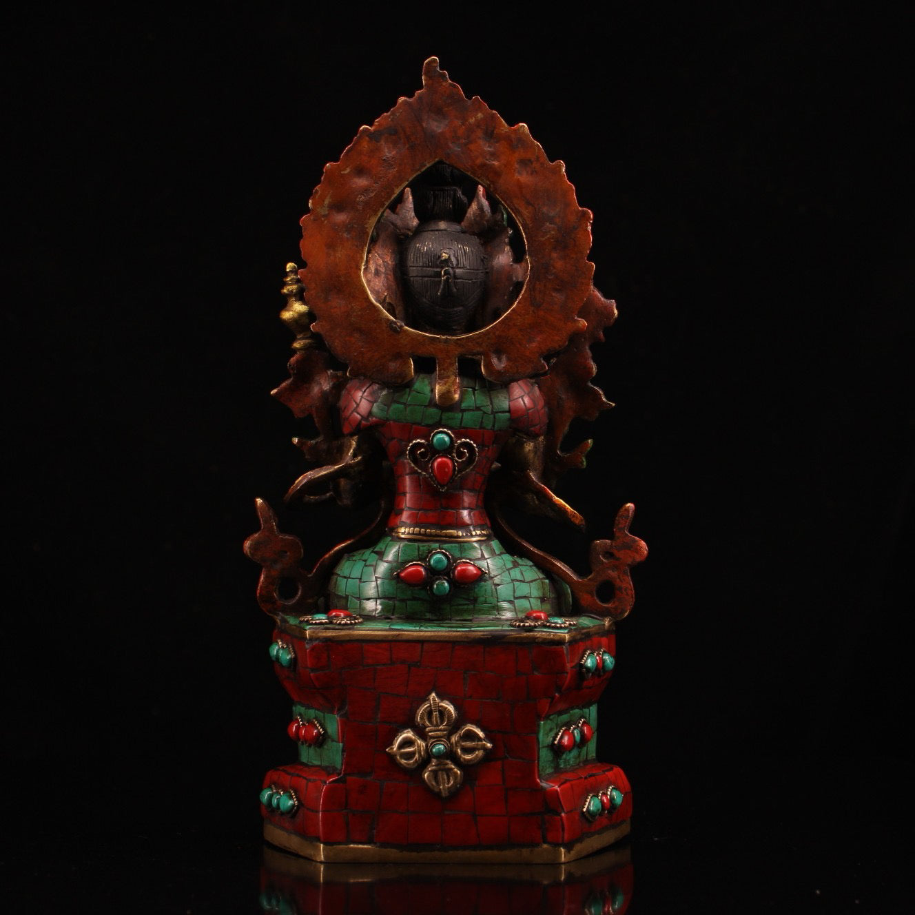 A pure copper handmade statue with inlaid gemstones, colorful paintings, and golden depictions, featuring a Buddha statue