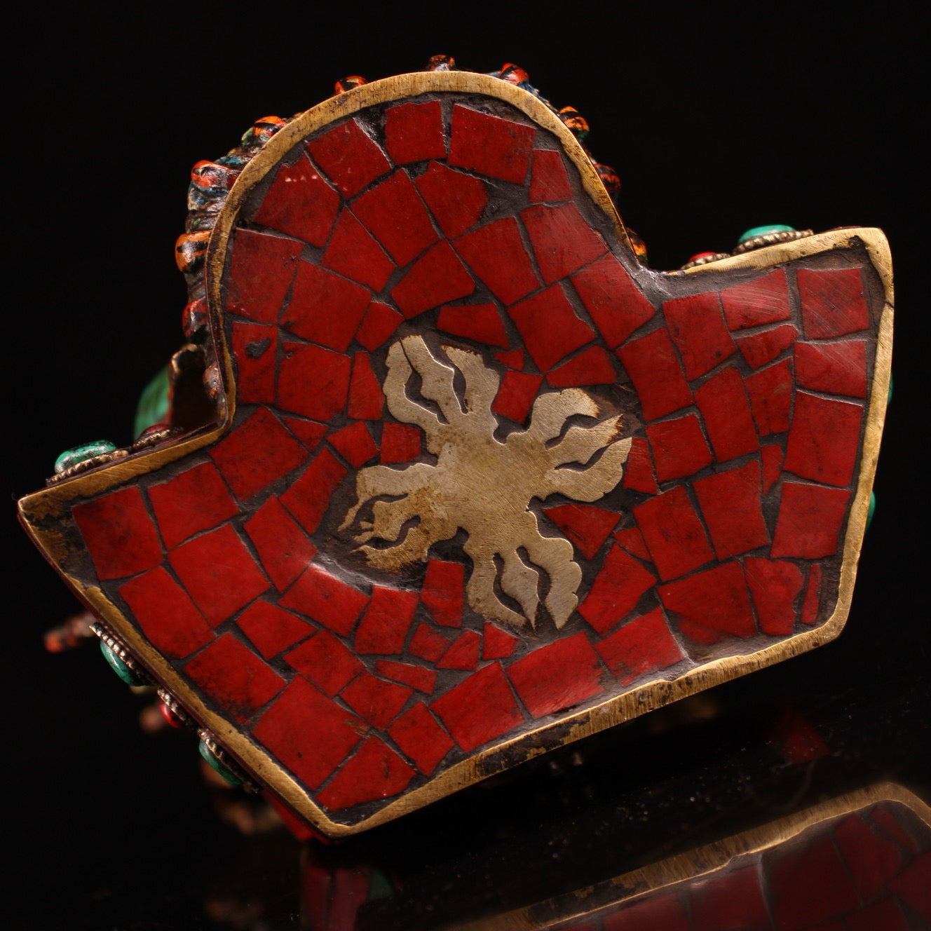 A pure copper handmade statue with inlaid gemstones, colorful paintings, and golden depictions, featuring a Buddha statue