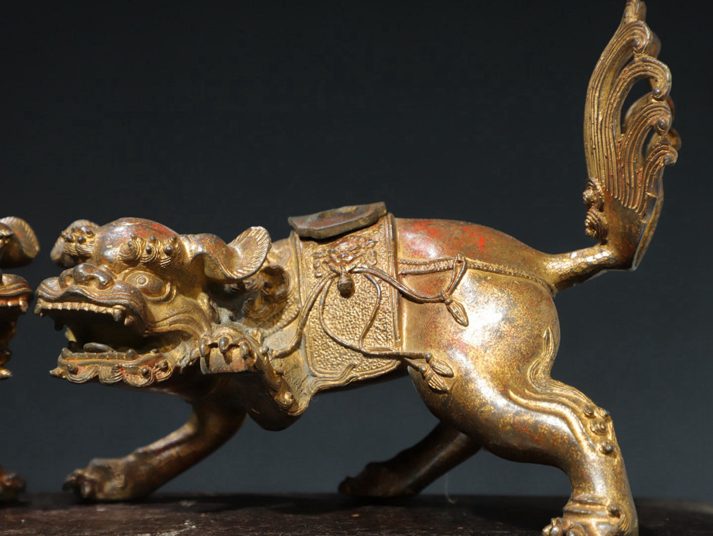 A pair of copper and gold [lion] ornaments