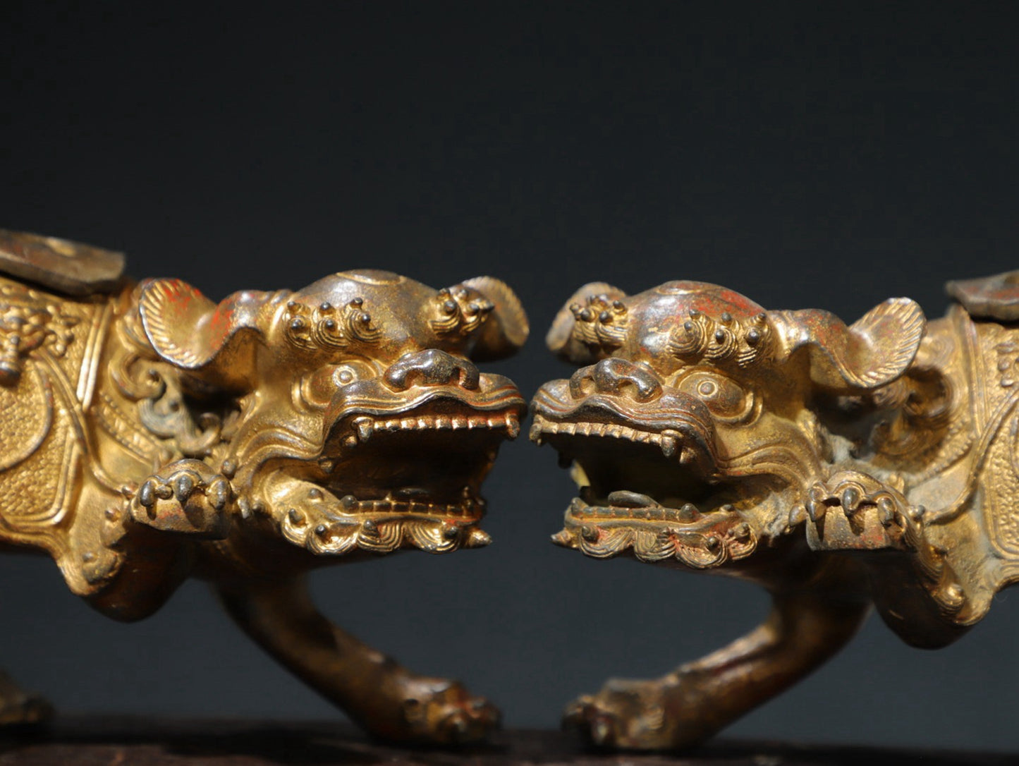 A pair of copper and gold [lion] ornaments