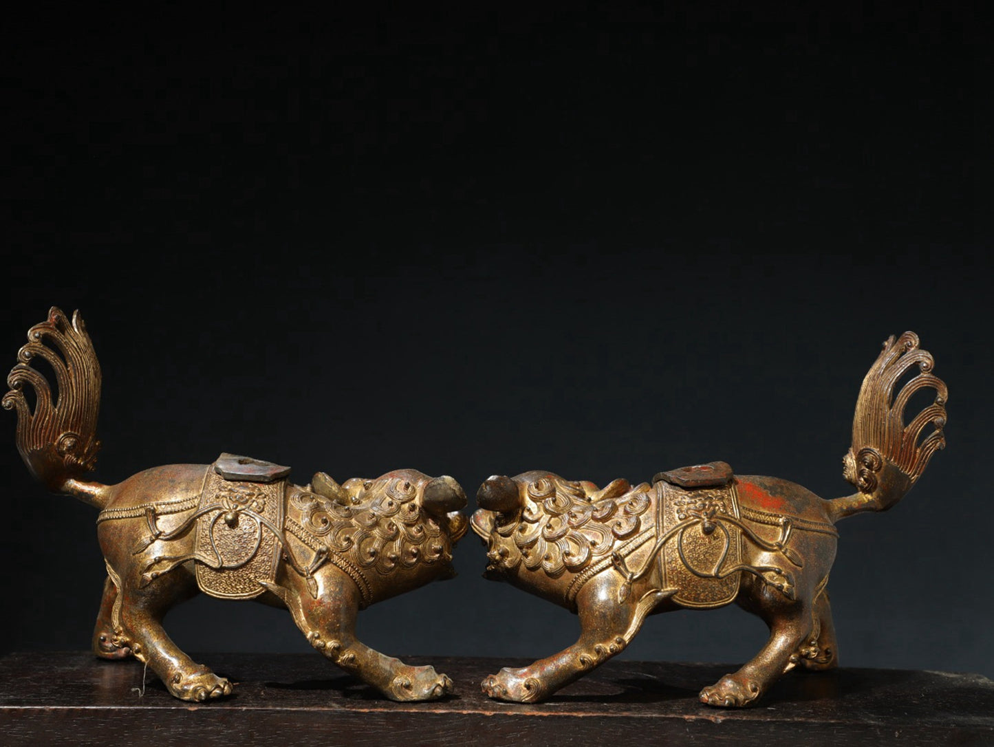 A pair of copper and gold [lion] ornaments