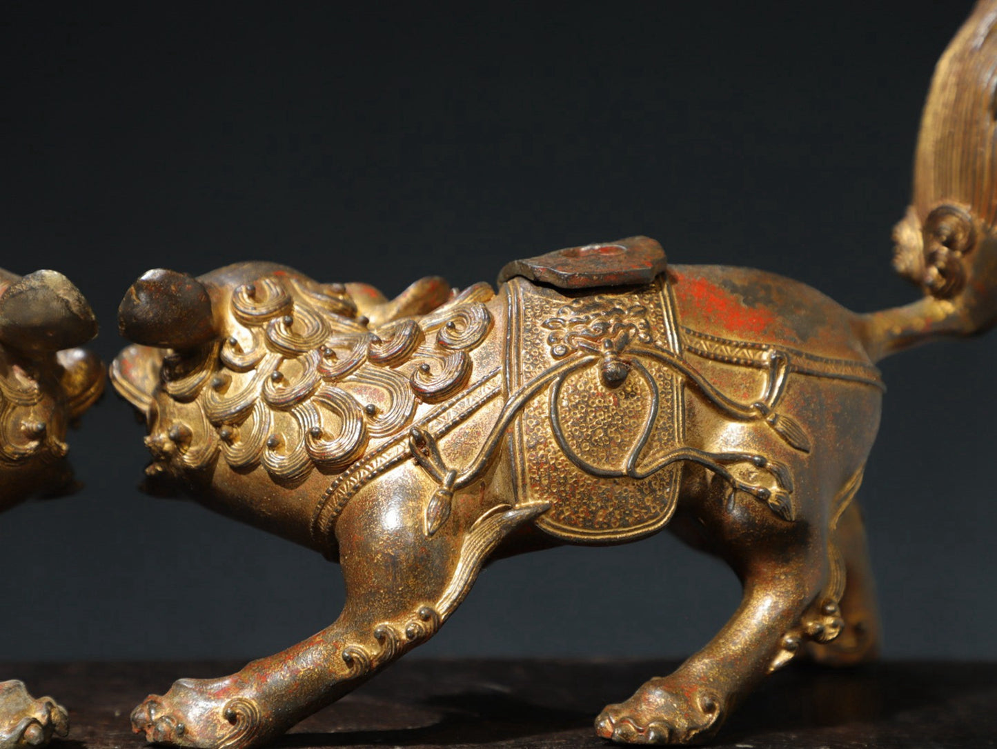 A pair of copper and gold [lion] ornaments