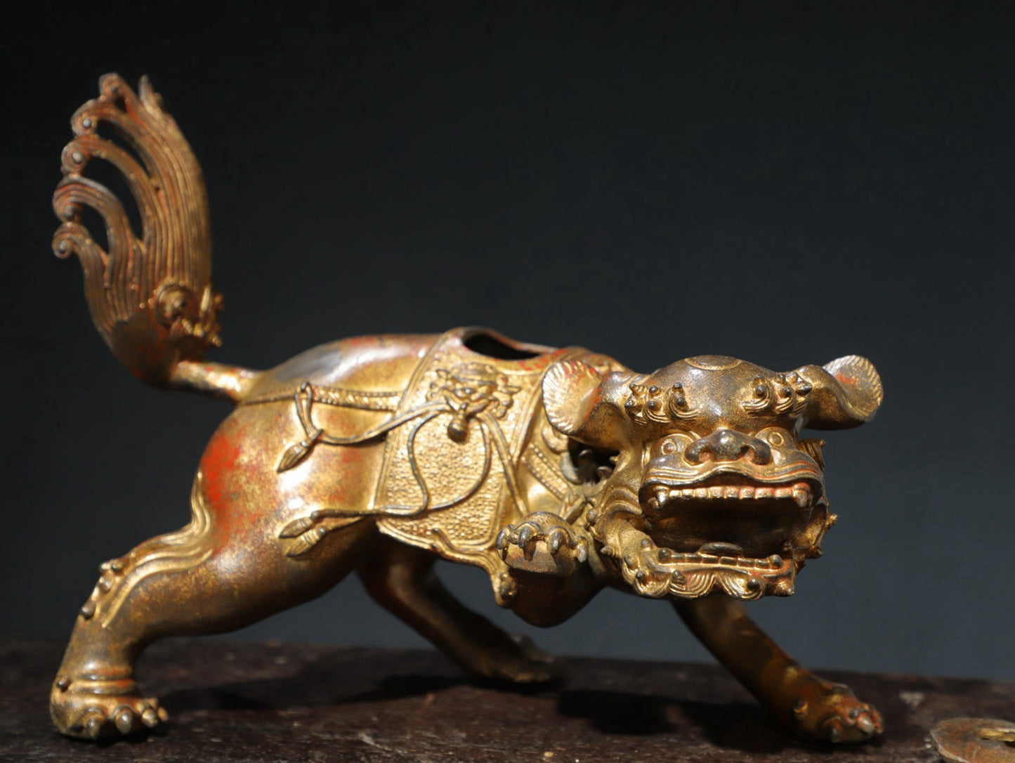 A pair of copper and gold [lion] ornaments