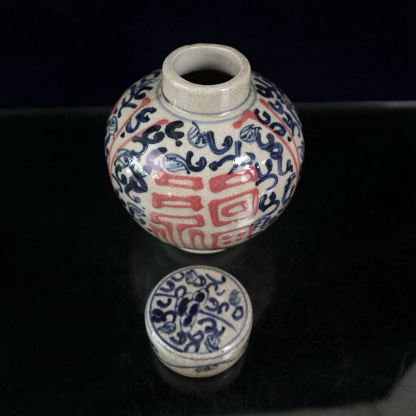 Open-piece blue and white glazed jar with a red blessing pattern lid