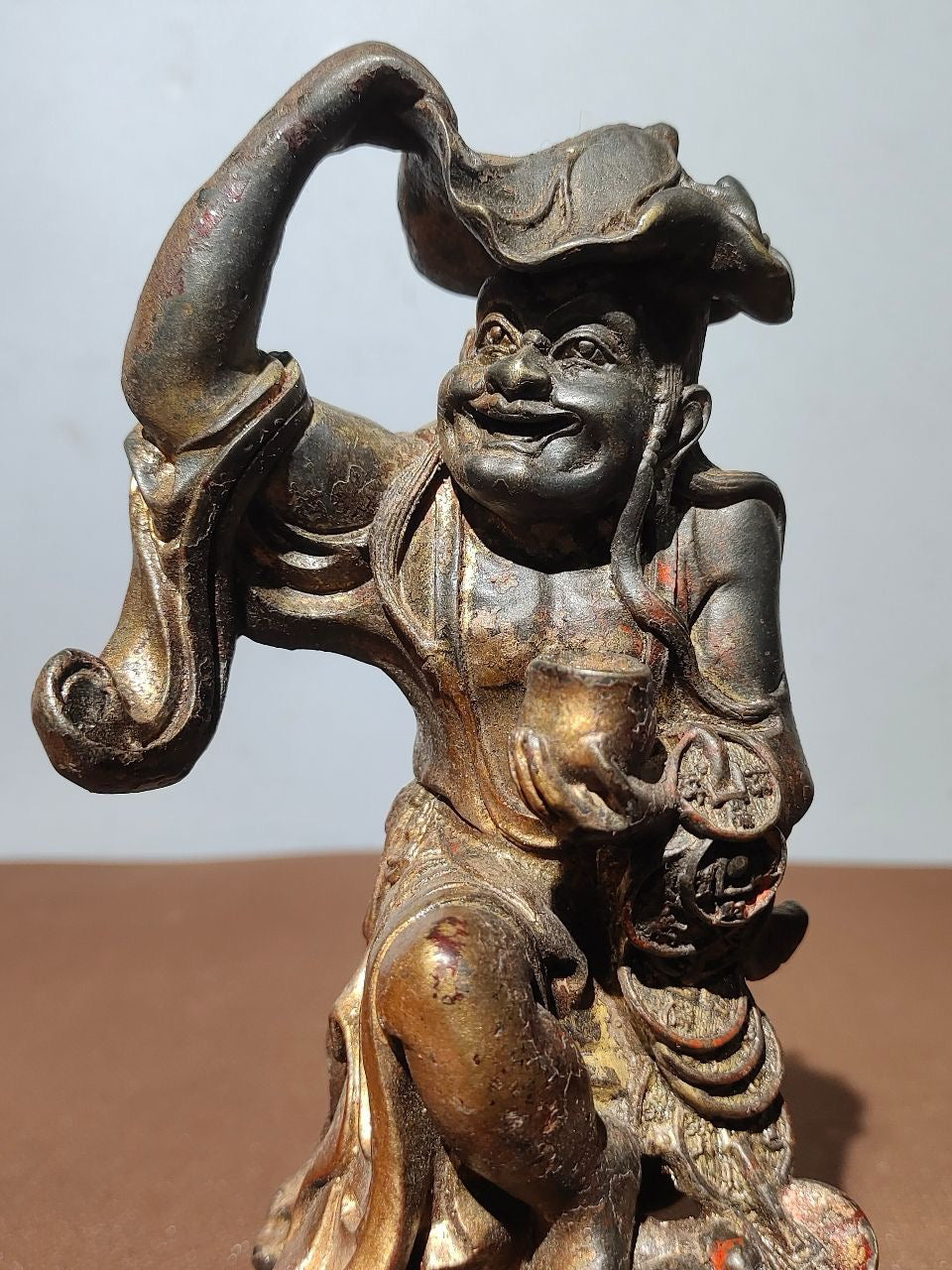 Buddha statue with old copper body, mud and gold, blooming and scattering cinnabar