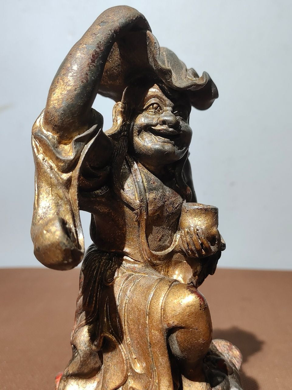 Buddha statue with old copper body, mud and gold, blooming and scattering cinnabar