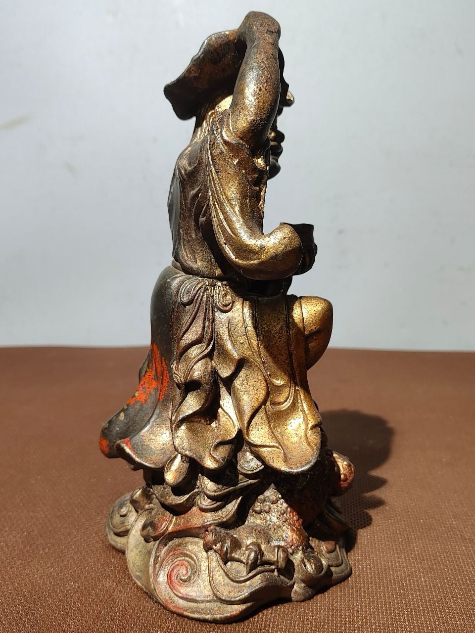 Buddha statue with old copper body, mud and gold, blooming and scattering cinnabar