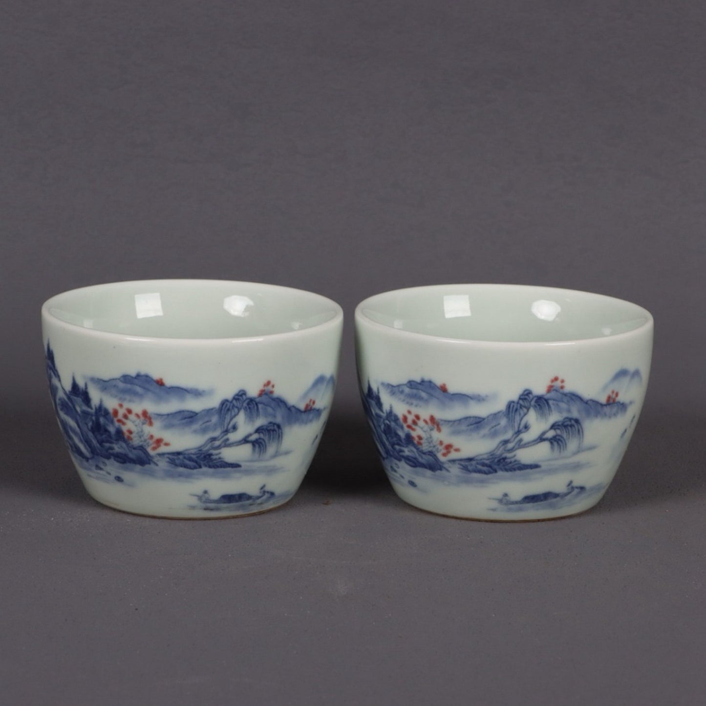 A pair of ceramic blue and white glazed flat bottomed cups