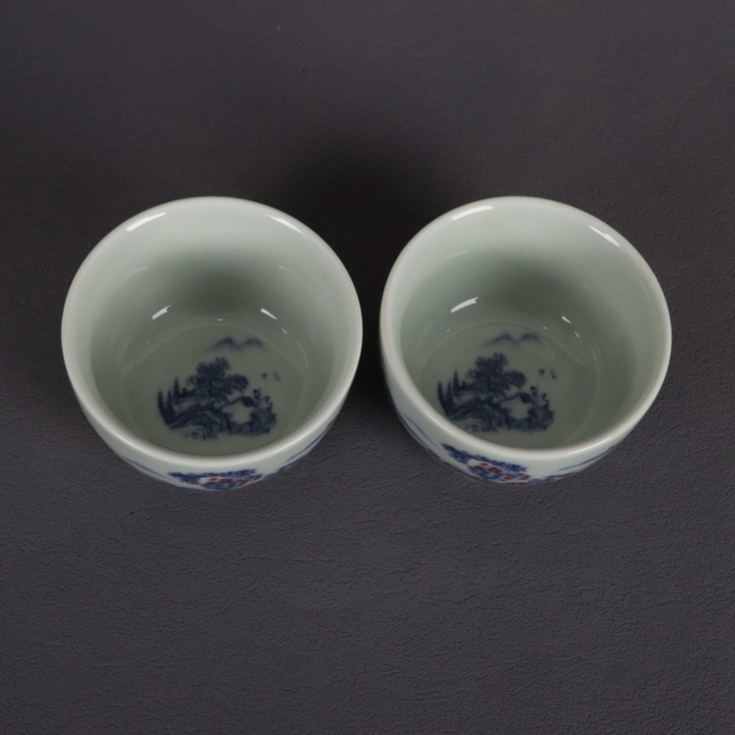 A pair of ceramic blue and white glazed flat bottomed cups