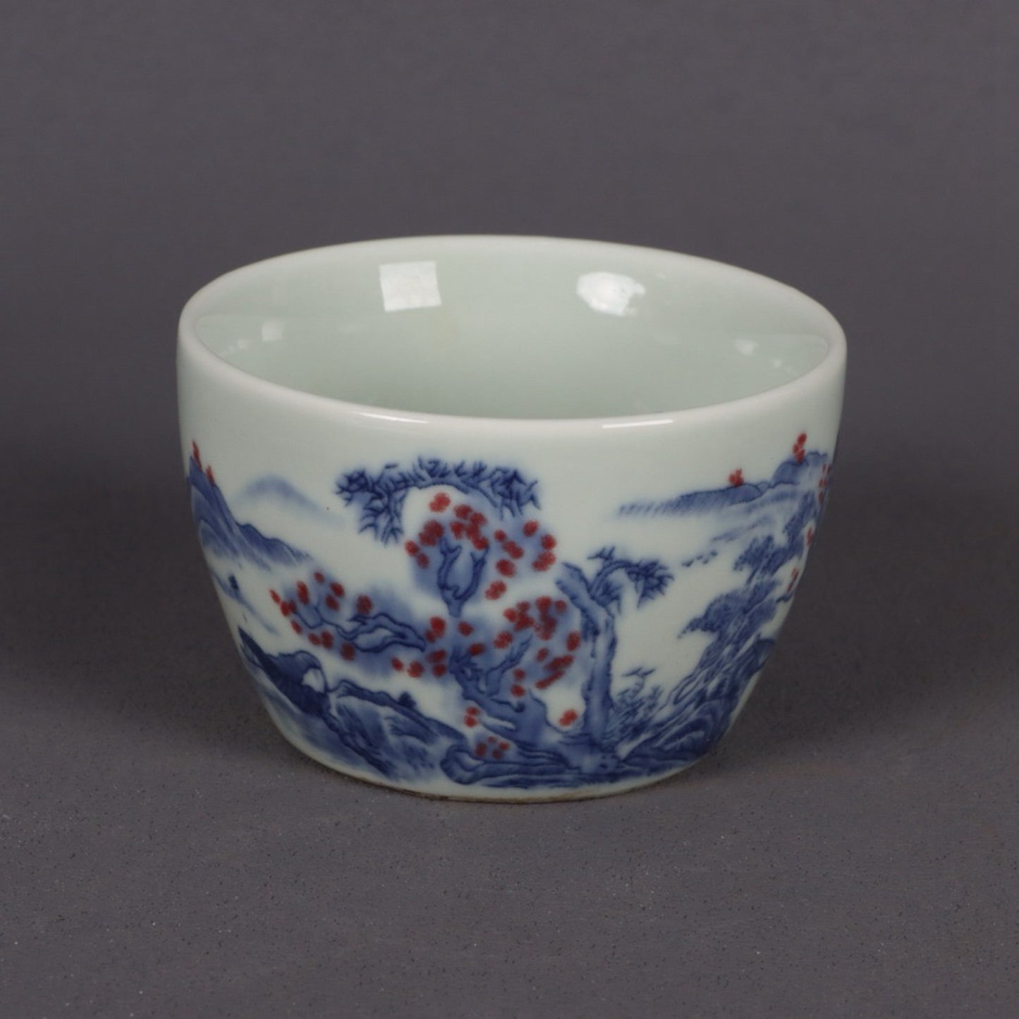 A pair of ceramic blue and white glazed flat bottomed cups