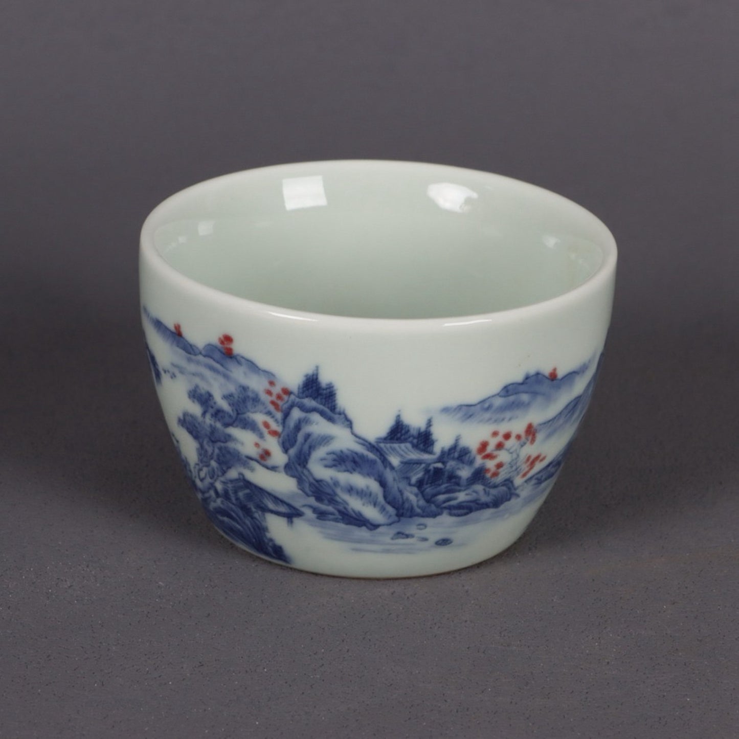 A pair of ceramic blue and white glazed flat bottomed cups