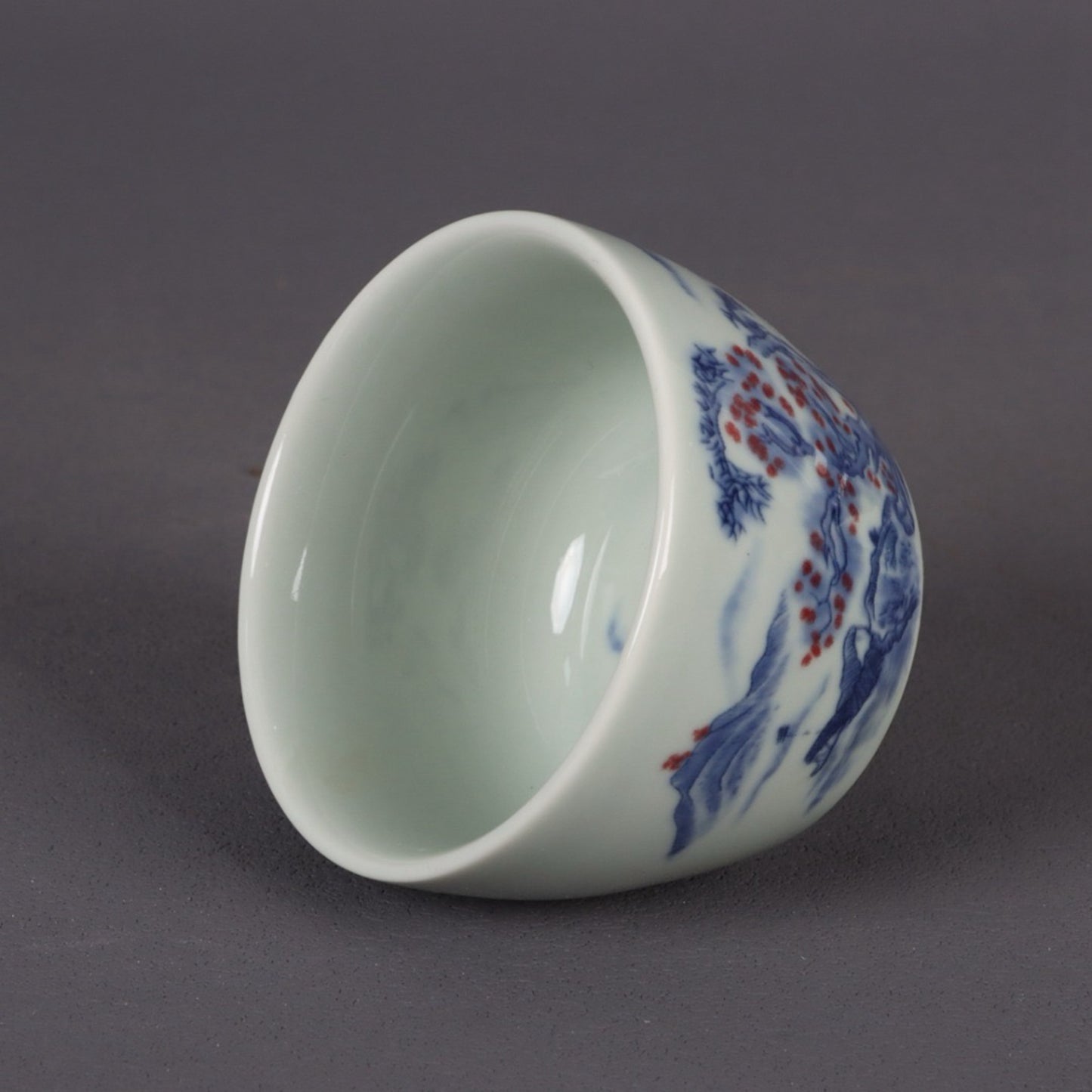 A pair of ceramic blue and white glazed flat bottomed cups