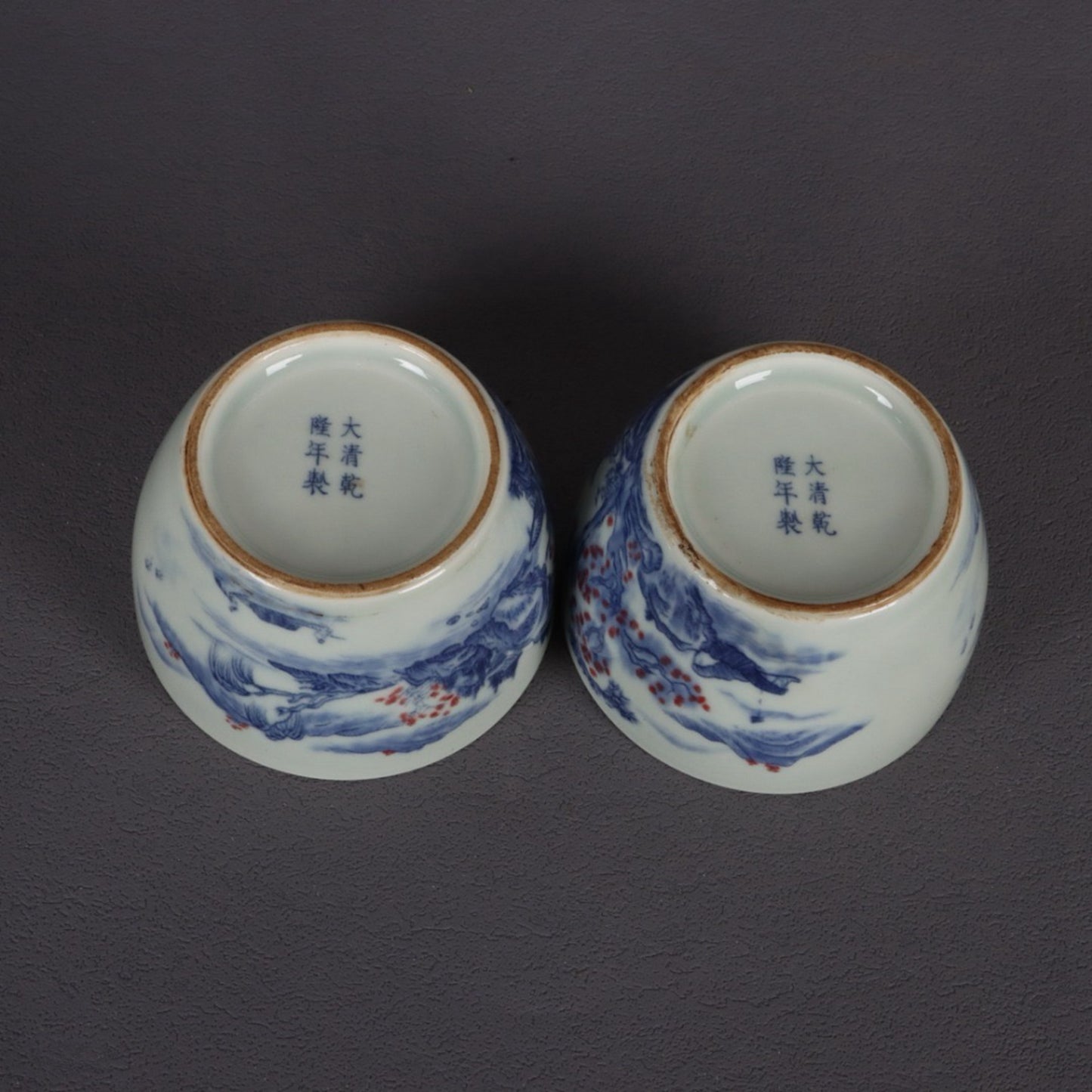 A pair of ceramic blue and white glazed flat bottomed cups