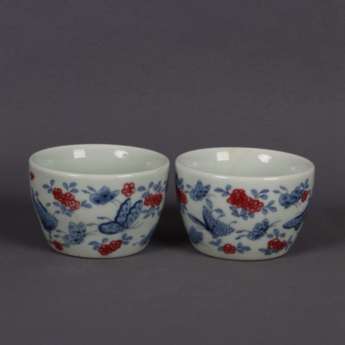 A pair of ceramic blue and white glazed flat bottomed cups