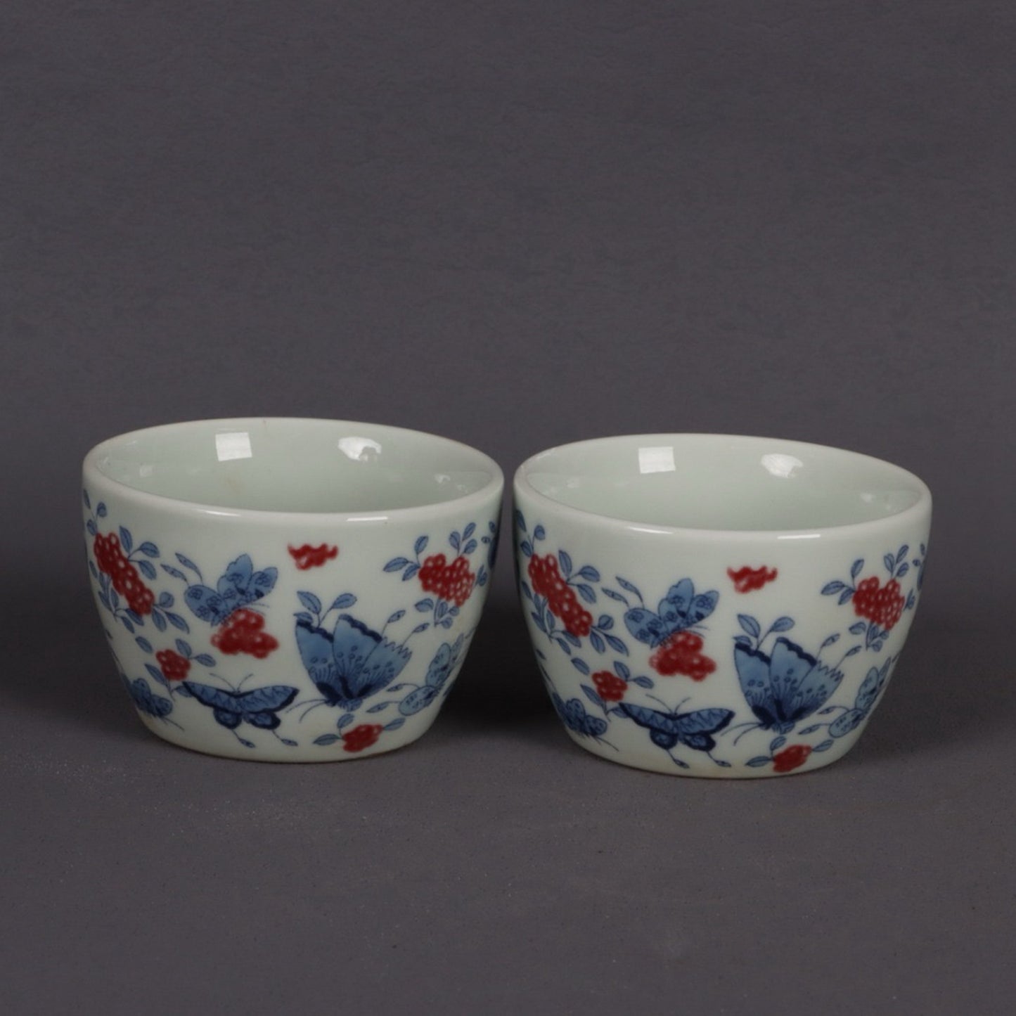 A pair of ceramic blue and white glazed flat bottomed cups