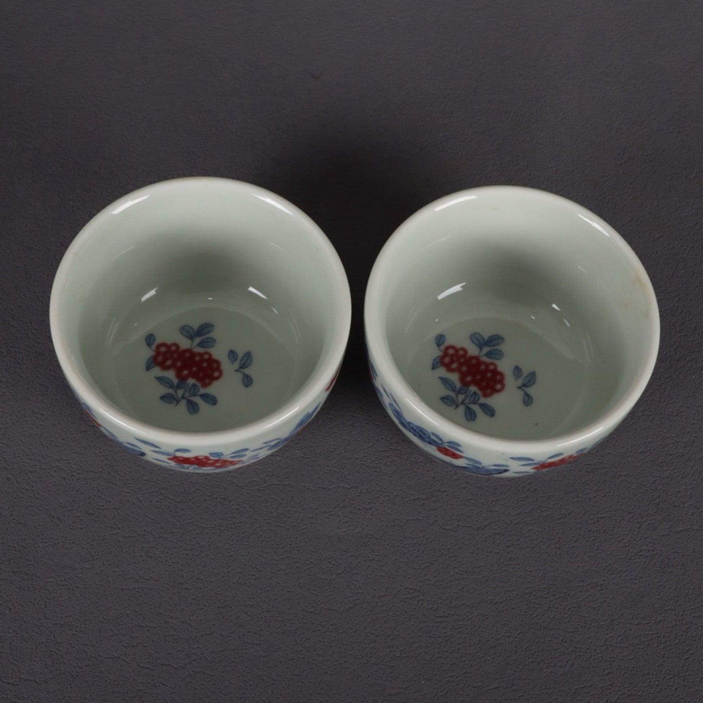 A pair of ceramic blue and white glazed flat bottomed cups