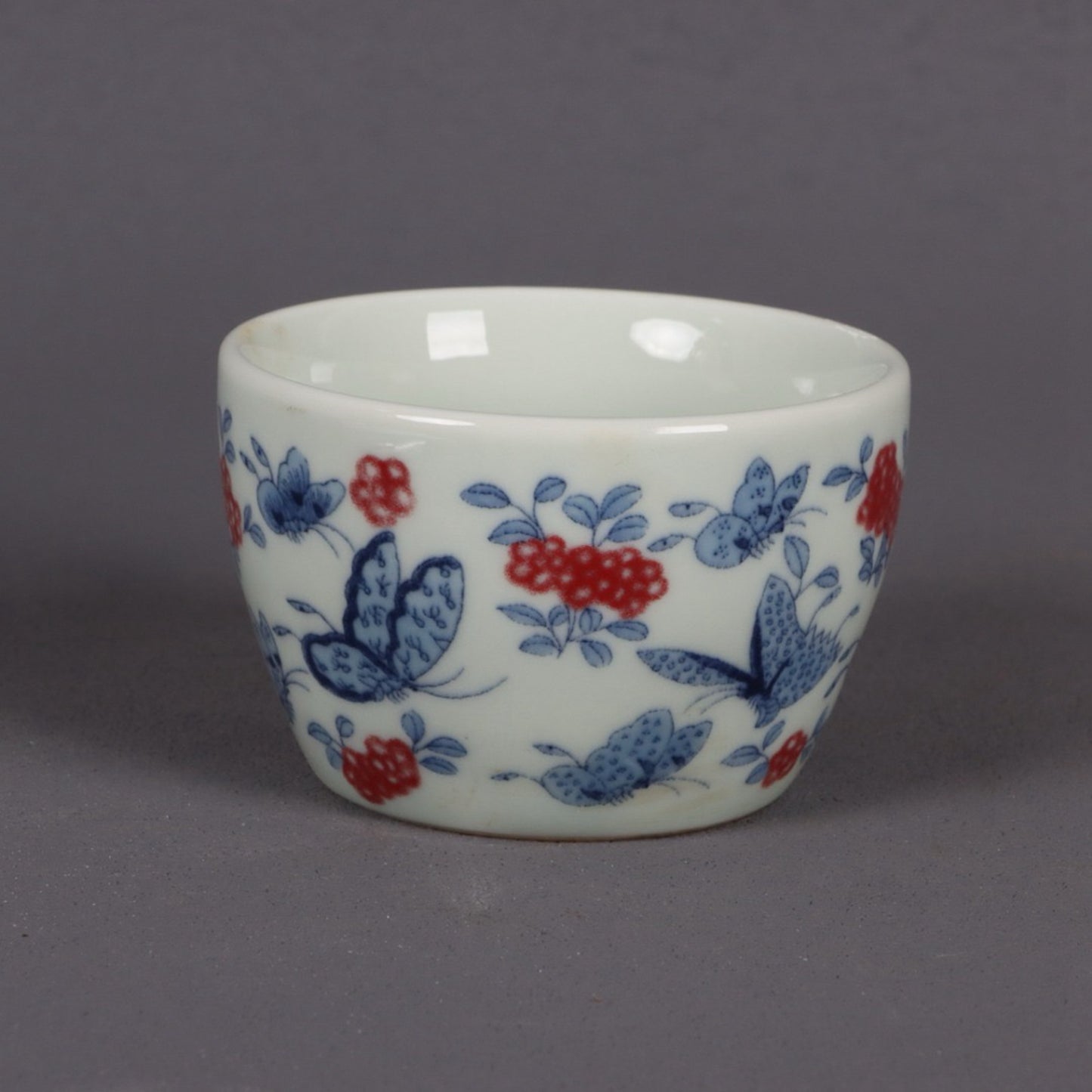 A pair of ceramic blue and white glazed flat bottomed cups