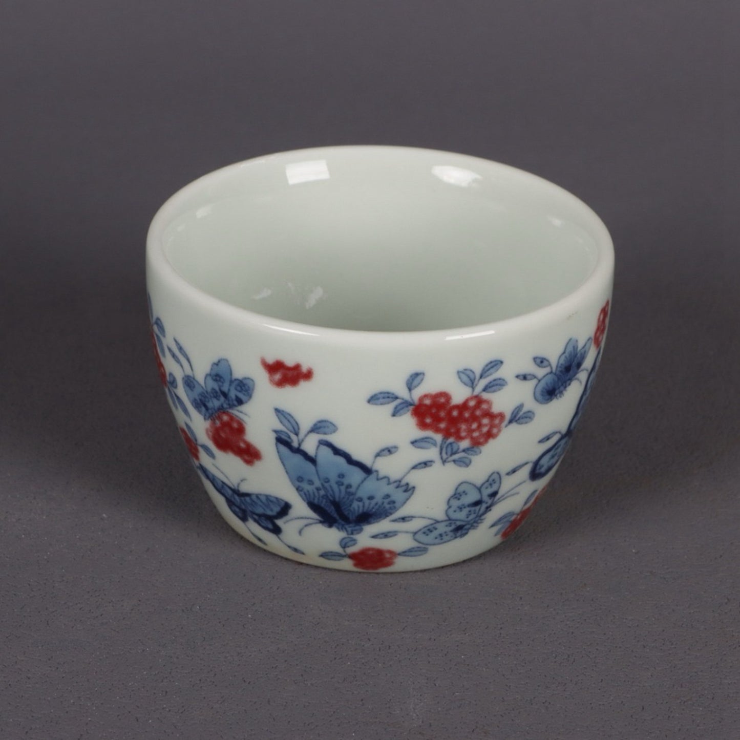 A pair of ceramic blue and white glazed flat bottomed cups